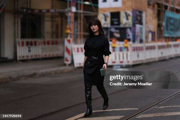 Jihoon Kim seen wearing a full Fendi look, black turtleneck shirt, black skirt, belt, leather high boots and a Fendi turkey mini peekaboo bag on...