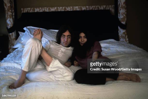 British musican and artist John Lennon and Japanese-born artist and musician Yoko Ono pose together on a bed, December 1968.