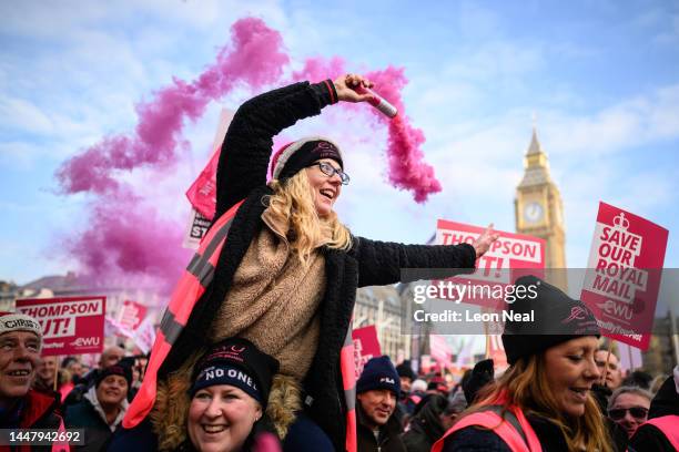 Woman waves a smoke flare as striking mail workers and supporters gather in Parliament Square to listen to speeches by union leaders and...