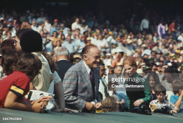British-American comedian and actor Bob Hope in the stands during an 1973 World Series match between the Oakland Athletics and the New York Mets, at...