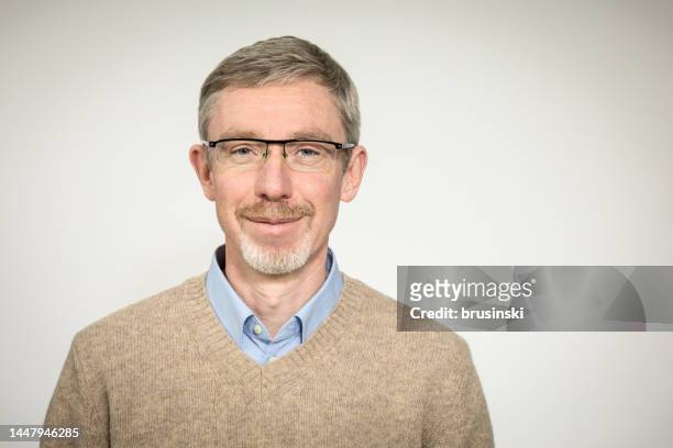 白い背景にベージュのセーターに眼鏡をかけた50歳の白いひげを生やした男性の接写 - old man and glasses ストックフォトと画像