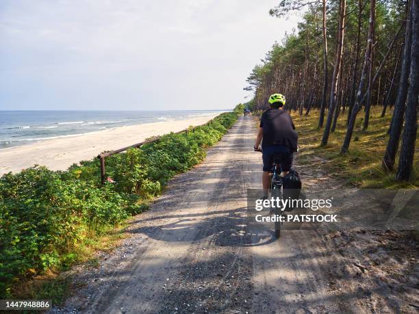 rear view of a boy riding a bicycle. - poland sea stock pictures, royalty-free photos & images