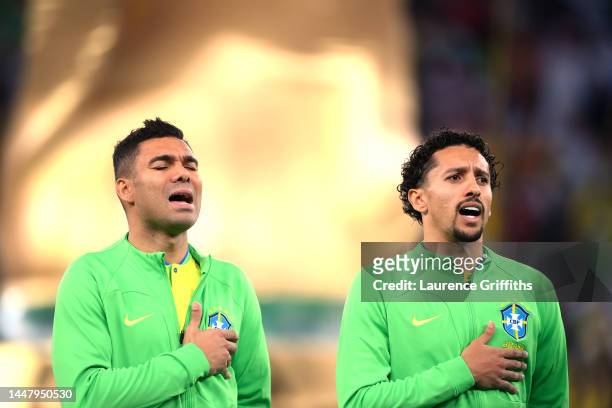 Casemiro and Marquinhos of Brazil sing their national anthem prior to the FIFA World Cup Qatar 2022 quarter final match between Croatia and Brazil at...