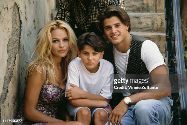 Canadian actress Pamela Anderson, wearing a floral print mini dress, American actor Jeremy Jackson, and French actor David Charvet attend a...