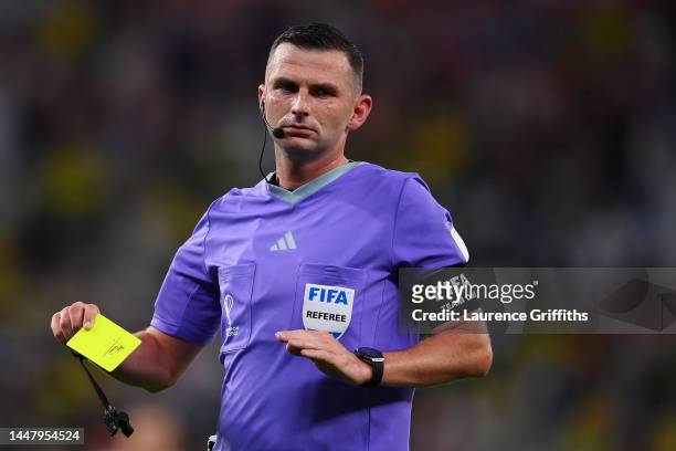 Referee Michael Oliver shows a yellow card to Danilo of Brazil during the FIFA World Cup Qatar 2022 quarter final match between Croatia and Brazil at...