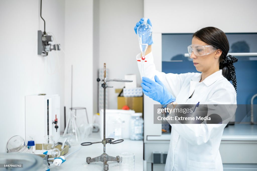 Braunhaarige Wissenschaftlerin mit einer Pipette während eines Experiments in einem Labor gesehen