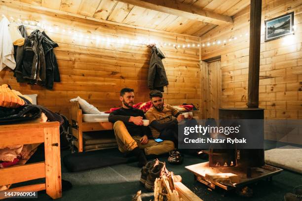 zwei männliche reisende in einer gemütlichen wohnung in zuflucht im himalaya - notunterkunft stock-fotos und bilder