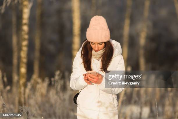 brunette woman holding mobile phone - the who february 21 stock pictures, royalty-free photos & images