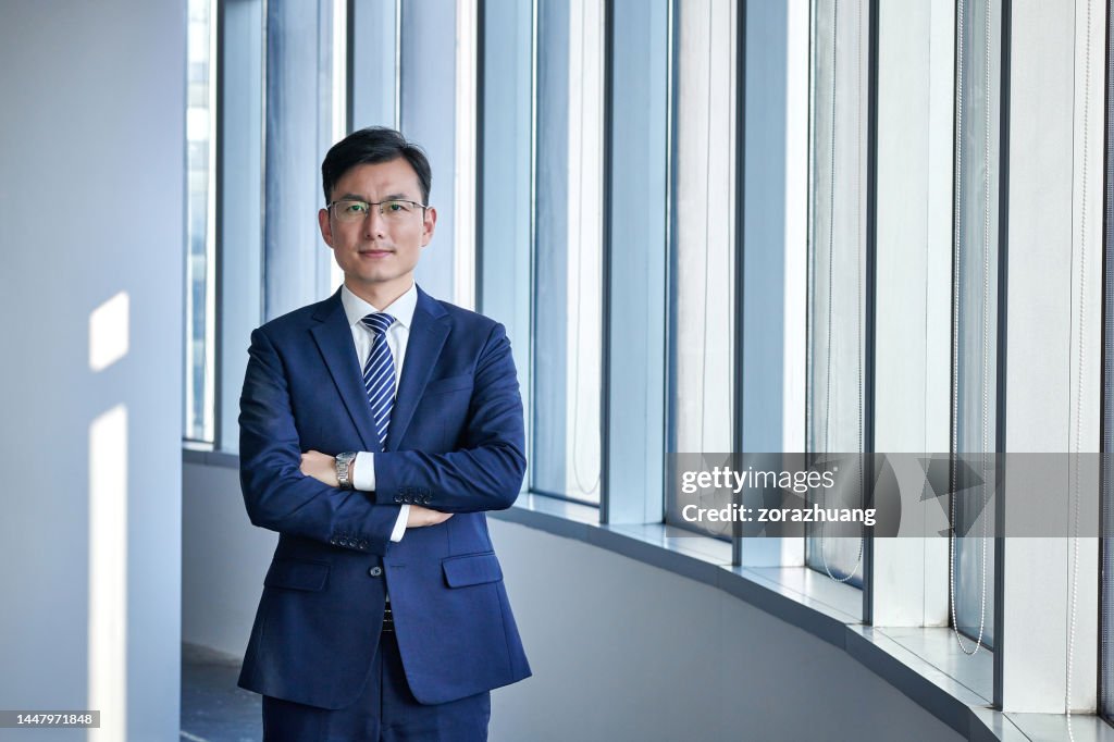 One Asian Businessman Standing at Window