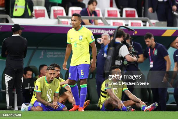 Alex Sandro of Brazil reacts with Raphinha after the loss via a penalty shootout during the FIFA World Cup Qatar 2022 quarter final match between...