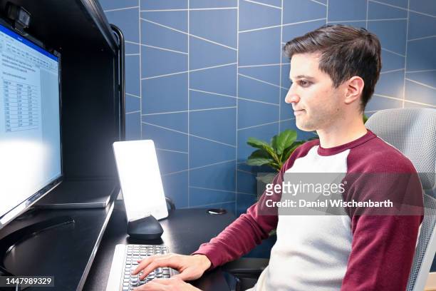 jeune homme utilisant une lampe de thérapie au bureau à domicile - luminothérapie photos et images de collection