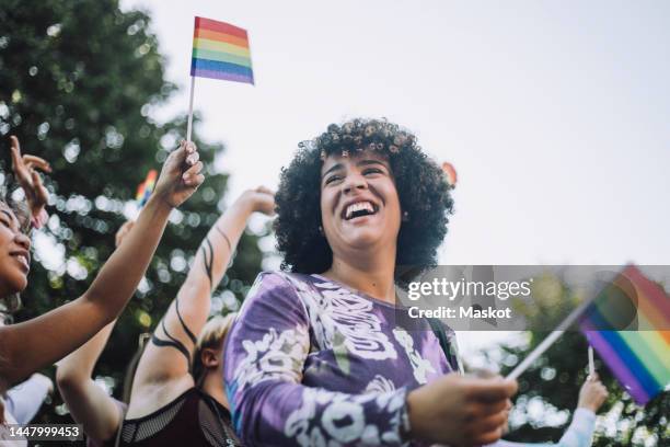 happy transgender woman with rainbow flag enjoying in gay pride parade - pride stock pictures, royalty-free photos & images