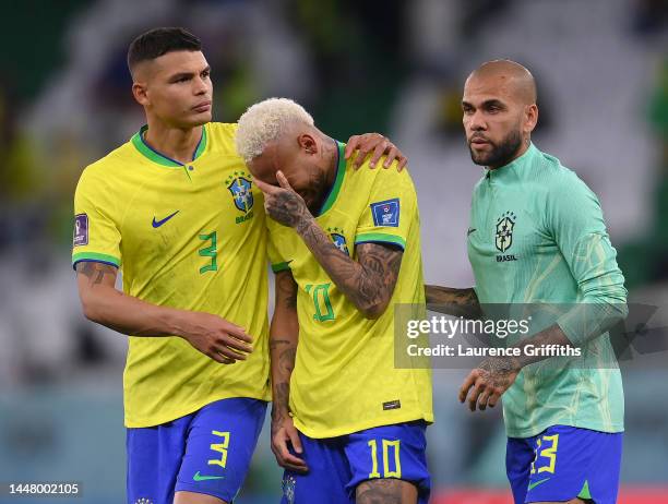 Neymar of Brazil is consoled by Thiago Silva and Dani Alves after the loss via a penalty shootout during the FIFA World Cup Qatar 2022 quarter final...