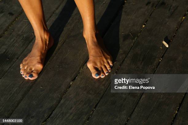 barefoot woman with bunions standing on wooden floor on sunny summer day, top view - hallux valgus 個照片及圖片檔