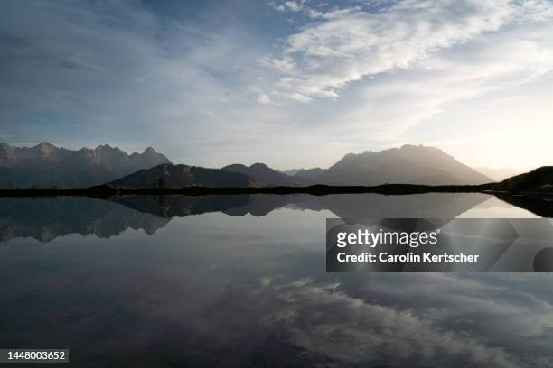sunrise and perfect reflection at a mountain lake | tyrol, austria - ruhige szene stock-fotos und bilder