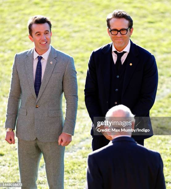 King Charles III talks with co-owners of Wrexham AFC Rob McElhenney and Ryan Reynolds as he visits Wrexham Association Football Club on December 9,...