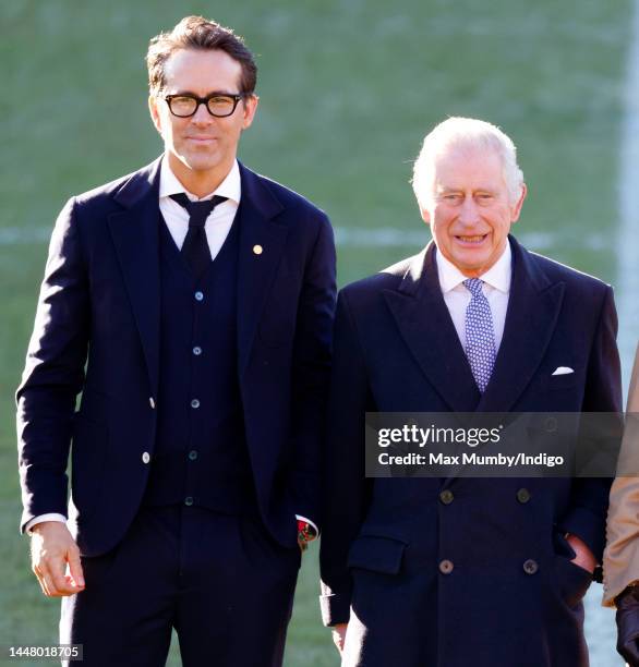 King Charles III talks with co-owner of Wrexham AFC Ryan Reynolds as he visits Wrexham Association Football Club on December 9, 2022 in Wrexham,...