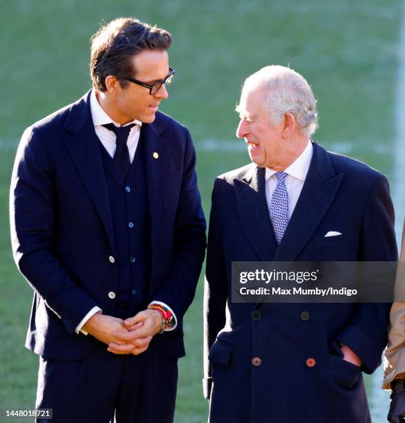 King Charles III talks with co-owner of Wrexham AFC Ryan Reynolds as he visits Wrexham Association Football Club on December 9, 2022 in Wrexham,...