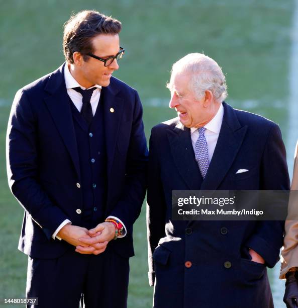 King Charles III talks with co-owner of Wrexham AFC Ryan Reynolds as he visits Wrexham Association Football Club on December 9, 2022 in Wrexham,...