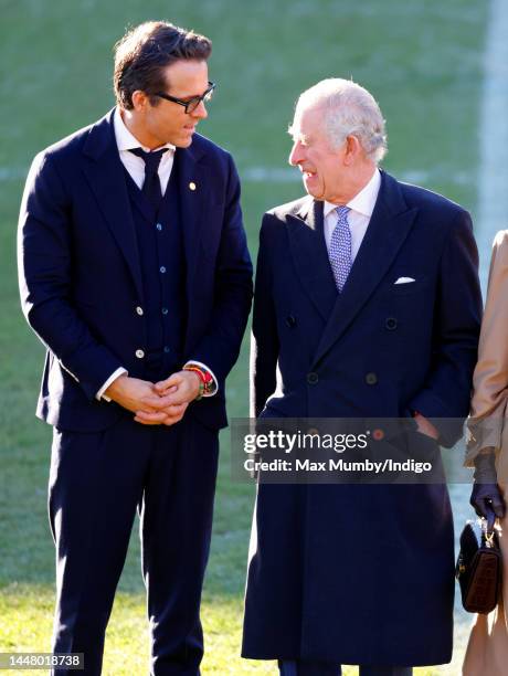 King Charles III talks with co-owner of Wrexham AFC Ryan Reynolds as he visits Wrexham Association Football Club on December 9, 2022 in Wrexham,...