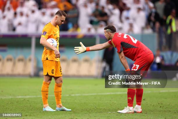 Goalkeeper Emiliano Martinez of Argentina gestures towards Teun Koopmeiners of Netherlands before Teun Koopmeiners takes and scores his sides third...