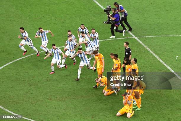 Argentina players celebrate after their win in the penalty shootout as Netherlands players react during the FIFA World Cup Qatar 2022 quarter final...