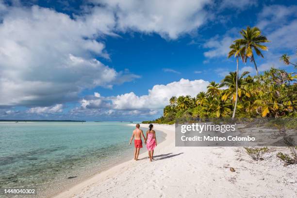 tourist couple walking on beach, cook islands - cook islands stock pictures, royalty-free photos & images