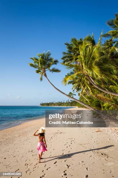 woman walking on exotic beach with palm trees, fiji - fiji people stock pictures, royalty-free photos & images