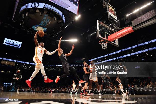 Aaron Holiday of the Atlanta Hawks grabs a rebound over Ben Simmons of the Brooklyn Nets during the 2nd half of the game at Barclays Center on...