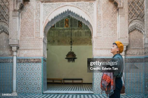 asiatische chinesische touristin bewundert die fes-moschee bou inania madressa - ceramics fez stock-fotos und bilder