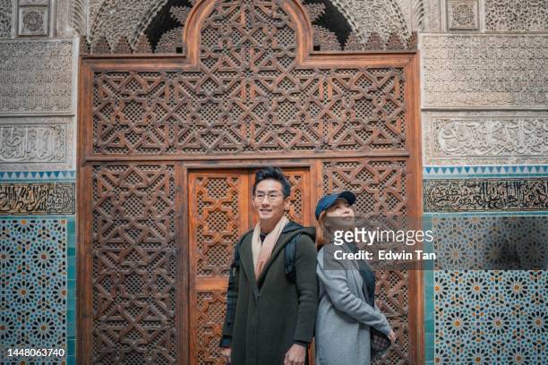 retrato asiático casal de turistas chineses em pé na mesquita de fez bou inania madressa - local religioso - fotografias e filmes do acervo