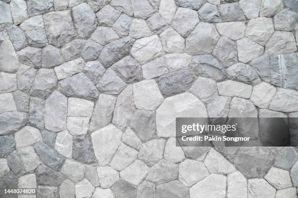 full frame shot of marble rock wall texture as background. - stone wall stock pictures, royalty-free photos & images