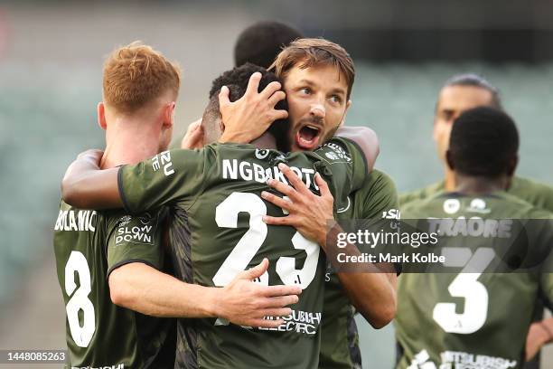Oliver Bozanic and Milos Ninkovic of the Wanderers congratulate Yeni Ngbakoto of the Wanderers as he celebrates scoring a goal during the round seven...
