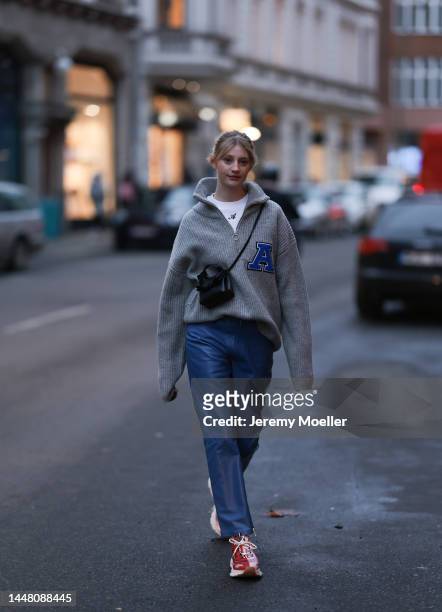 Trixi Giese seen wearing an oversized grey sweater by Axel Arigato, a white Axel Arigato shirt, blue pants by Martin Asbjorn, a black minibag by Axel...