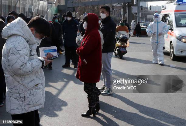 People line up to enter a fever clinic at a hospital as Beijing no longer requires people to show their negative nucleic acid testing results before...
