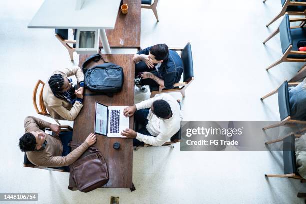 high angle view of people studying in a library - openbare bibliotheek stockfoto's en -beelden