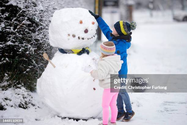 Children build a snowman after the first significant snow fall in Cheshire this Winter on December 10, 2022 in Northwich, United Kingdom. The UK...