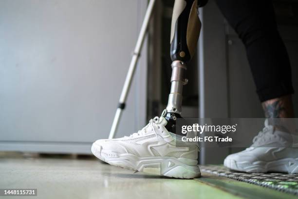 low section of a disabled woman walking with a walking cane - artificial foot stock pictures, royalty-free photos & images