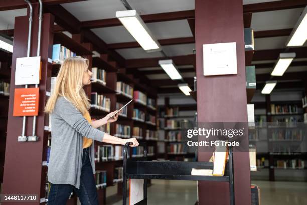 librarian putting books back in the library - librarian stock pictures, royalty-free photos & images