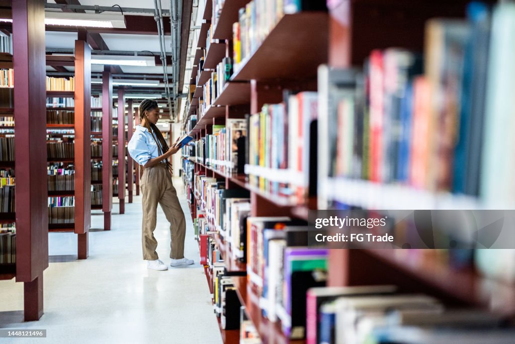 Young woman searching books in the library