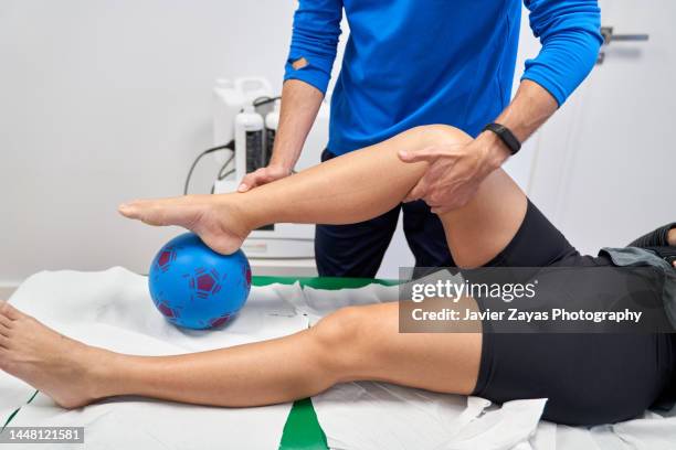 unrecognizable physiotherapist working with a female patient in his office - fisioterapista foto e immagini stock