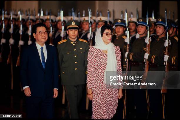 Chinese Premier Li Peng and Pakistani Prime Minister Benazir Bhutto walk together during a welcoming ceremony inside the Great Hall of the People,...