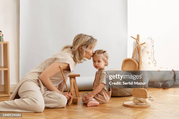 mom kissing daughter -stock photo - beige stock pictures, royalty-free photos & images