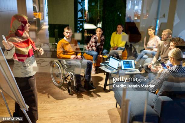 business colleagues in diversity inclusive meeting with a disabled person - multikulturalismus stock-fotos und bilder