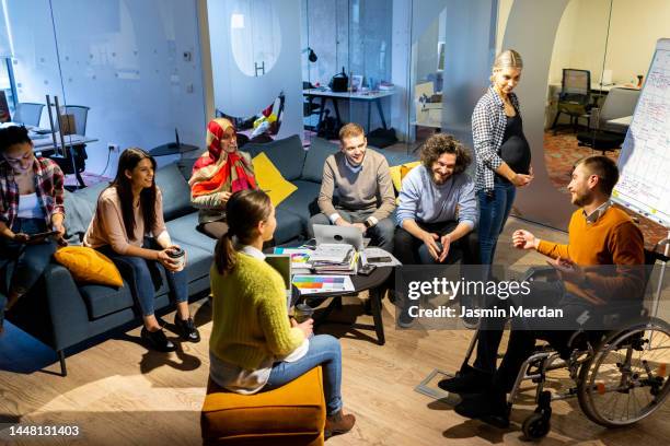 pregnant entrepreneur having presentation to  young businesspeople in office - integración social fotografías e imágenes de stock