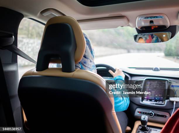 hijabi woman driving car - arab woman driving stockfoto's en -beelden