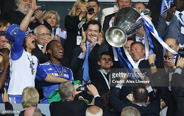 Club owner Roman Abramovich lifts the trophy in celebration while Chancellor of the Exchequer George Osborne applauds after their victory in the UEFA...