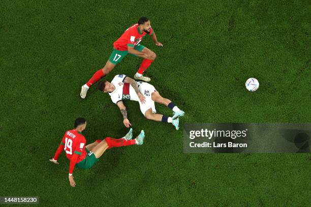 Otavio of Portugal battles for possession with Youssef En-Nesyri and Sofiane Boufal of Morocco during the FIFA World Cup Qatar 2022 quarter final...