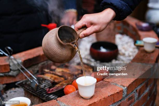 close-up of human hands serving chinese tea - am spieß gebraten stock-fotos und bilder