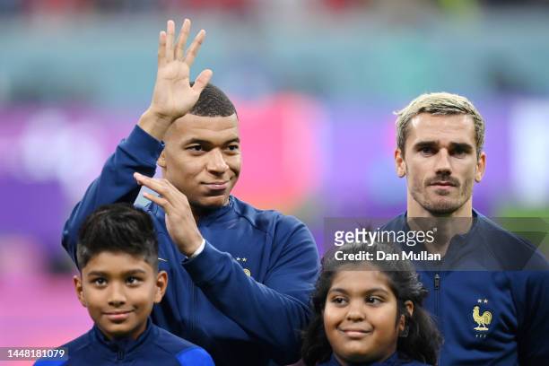 Kylian Mbappe and Antoine Griezmann of France sing the national anthem prior to the FIFA World Cup Qatar 2022 quarter final match between England and...